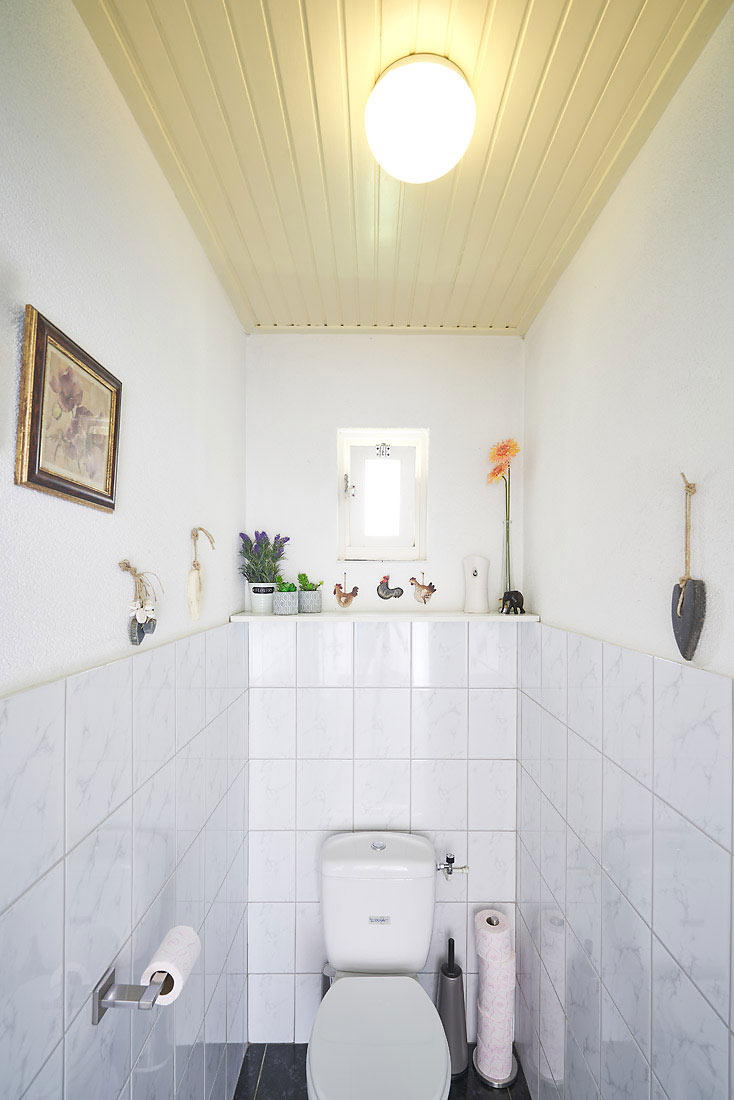 vergeeld schrootjesplafond in het toilet met wand tegels.