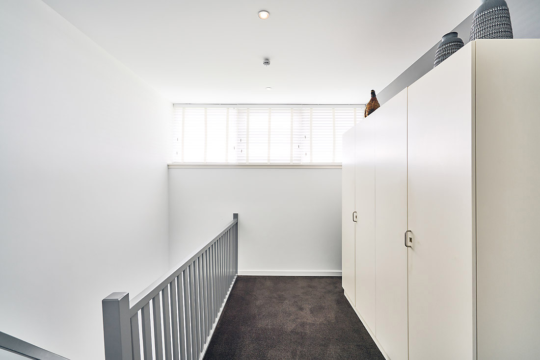 Plameco spanplafond in mat wit op de overloop met ingebouwde spot en brandmelder in het plafond